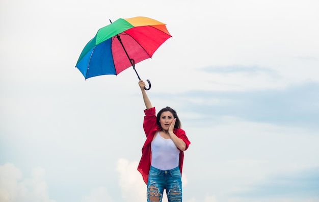 Gemakkelijk en gratis Goed weer Gastvrije herfst Mooie vrouw met kleurrijke paraplu Regenboogparaplu Regenachtig weer Goed humeur Goed humeur Open-minded persoon Meisje voelt zich goed hemelachtergrond