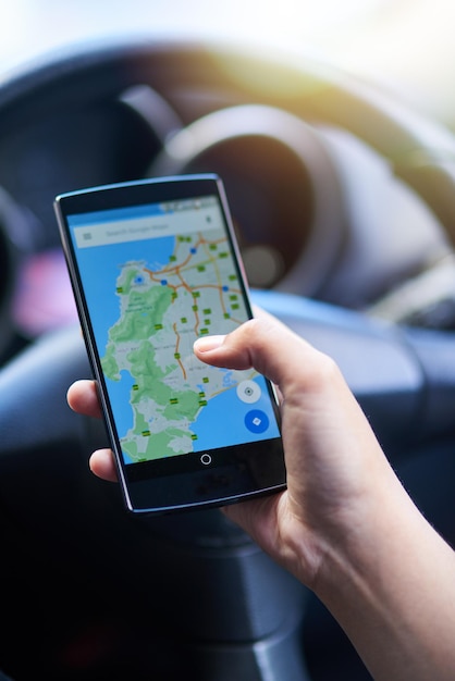 Gemakkelijke navigatie Foto van een persoon in een auto die zijn telefoon gebruikt om een routebeschrijving te vinden