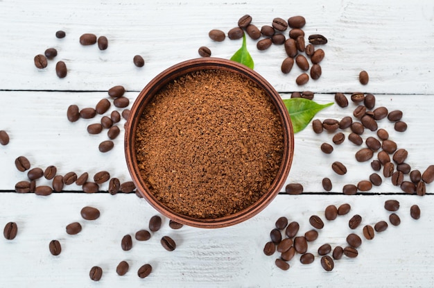 Gemalen koffie en koffiebonen Op een witte houten achtergrond Bovenaanzicht Vrije ruimte voor uw tekst