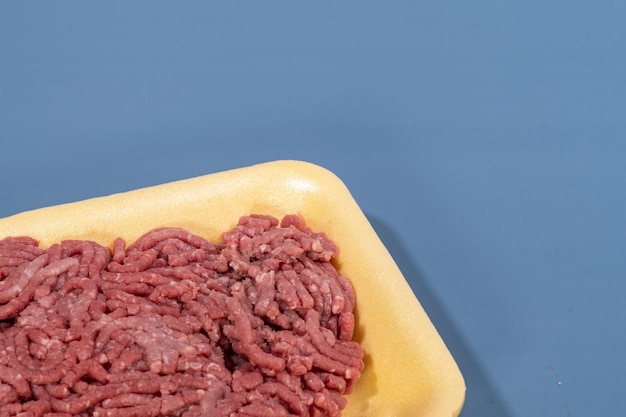 Gemalen rood vlees in gele foamboard