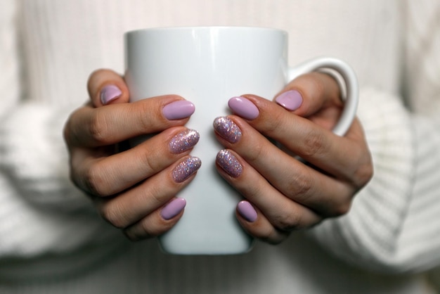 Gemanicuurde Womans Hands Holding Cup trendy pastelkleurige nagels Lente zomer ontwerp schoonheidssalon