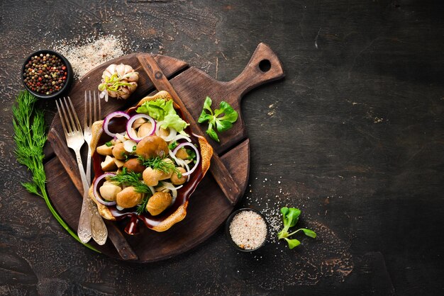 Gemarineerde champignons met uien en kruiden in een bord op een rustieke achtergrond bovenaanzicht banner