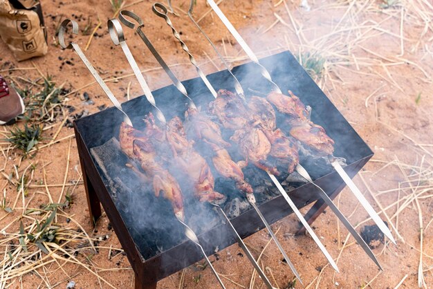 Gemarineerde kwartels op spiesjes op de grill bakken