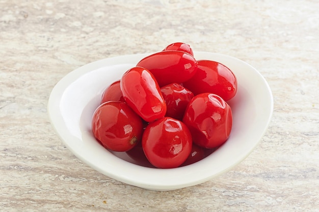 Gemarineerde rode tomaten ingelegde vitaminen in de schaal