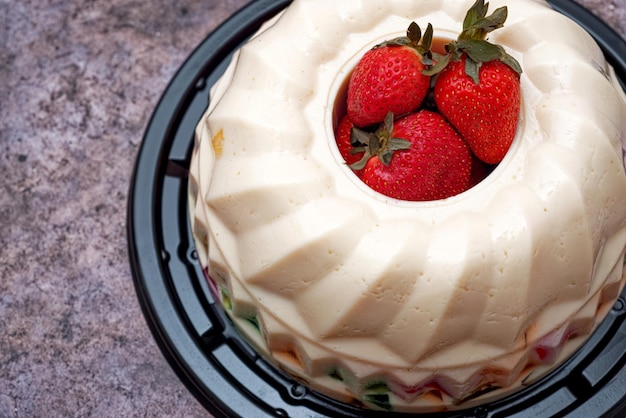 Gemarmerde gelei versierd met aardbeien op een betonnen tafel Geïsoleerd dessert op tafel