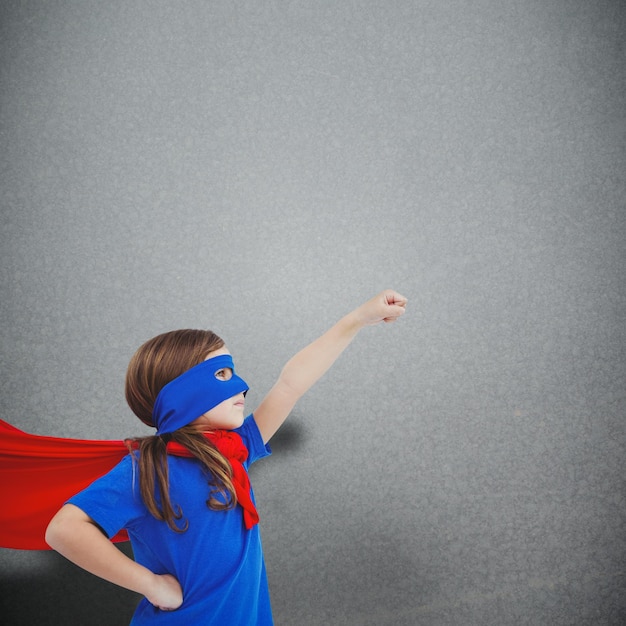 Foto gemaskerd meisje dat zich voordoet als superheld tegen een grijze achtergrond