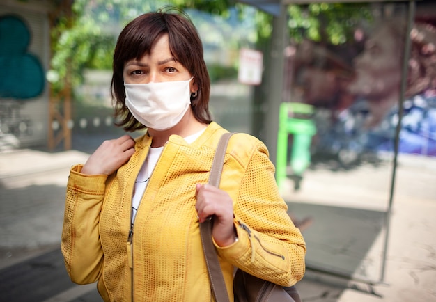 Gemaskerde vrouw buitenshuis tijdens coronavirus-pandemie