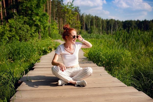 Gember charmante vrouw jonge mooie bos groen. Kaukasisch meisje ontspannen en genieten van het leven in de natuur buiten.