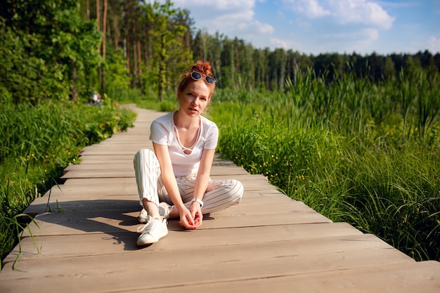 Foto gember charmante vrouw jonge mooie bos groen. kaukasisch meisje ontspannen en genieten van het leven in de natuur buiten.