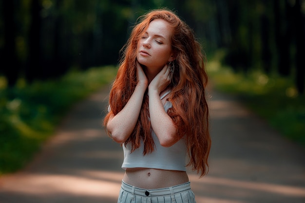 Gember jonge mooie vrouw poseren in een groen bos