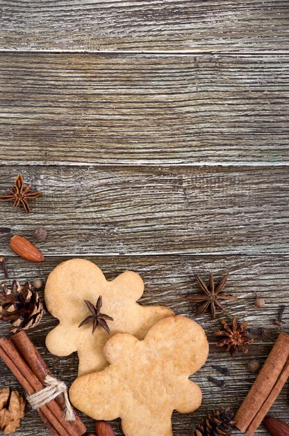Gember koekjes op een houten tafel met kruiden.