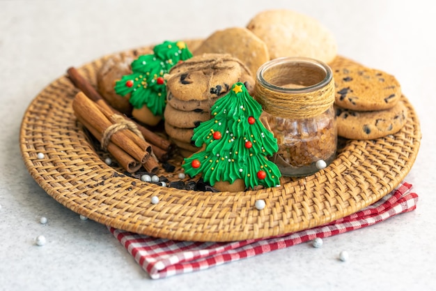 Foto gemberbrood in de vorm van een kerstboom en koekjes in een rieten bord
