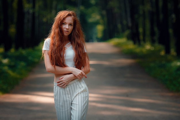 Gembervrouw in vrijetijdskleding in een weg op een bosachtergrond