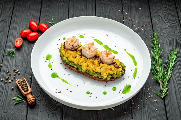 Foto gemengd op toast met guacamole garnalen en olijven gezond en smakelijk ontbijt op een bord