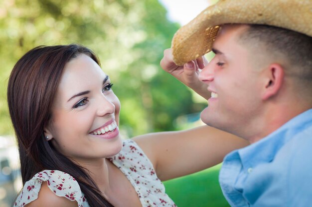 Gemengd ras romantisch stel met cowboy hoed flirt in het park