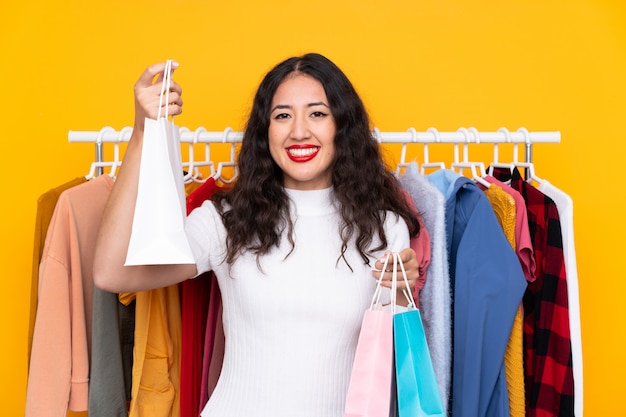 Gemengd ras vrouw in een kledingwinkel en met boodschappentassen