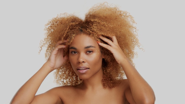 Gemengd ras zwart blond model met krullend haar op wit afro blond haar