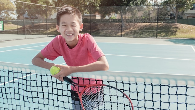 Gemengde Aziaat preteen tween het tennisbal en racket van de jongensholding, tween sport, jong geitje actieve levensstijl