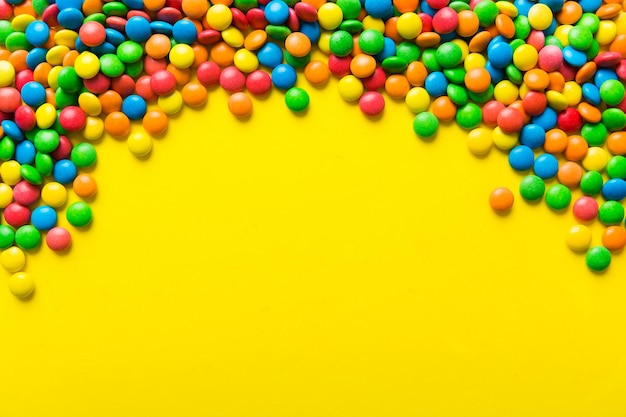 Gemengde collectie van kleurrijke snoepjes op gekleurde achtergrond Plat lag bovenaanzicht frame van kleurrijke chocolade gecoate snoepjes