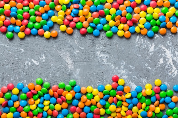 Gemengde collectie van kleurrijke snoepjes op gekleurde achtergrond Plat lag bovenaanzicht frame van kleurrijke chocolade gecoate snoepjes