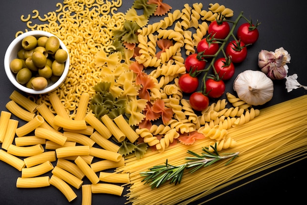 Foto gemengde gedroogde pasta met smakelijke gezonde ingrediënten