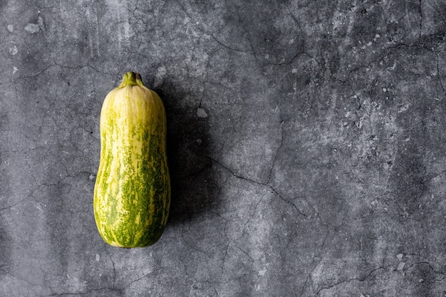 Gemengde gele, witte, gestripte en groene courgette's op een grijze betonnen ondergrond