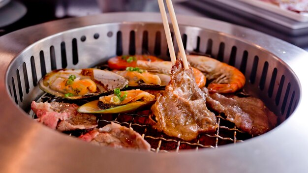 Gemengde geroosterd vlees en zeevruchten en eetstokjes op de BBQ Grill op gebraden.