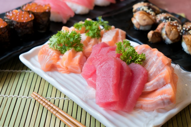 Foto gemengde gesneden vissensashimi in witte plaat. sashimi zalm en tonijn met tonijn