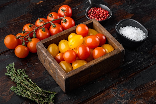 Gemengde kleur cherrytomaatjes in houten dienblad, op oude houten tafel