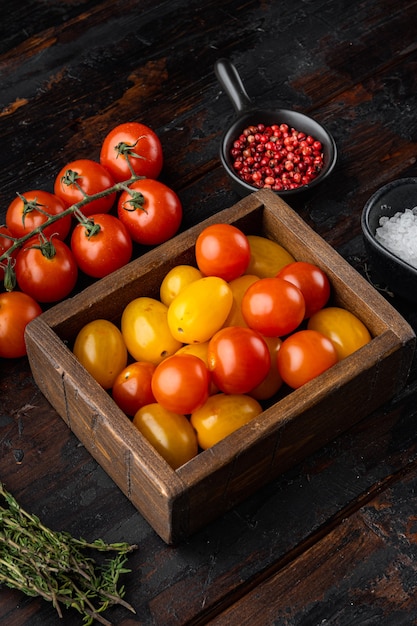 Gemengde kleur cherrytomaatjes in houten dienblad, op oude houten tafel