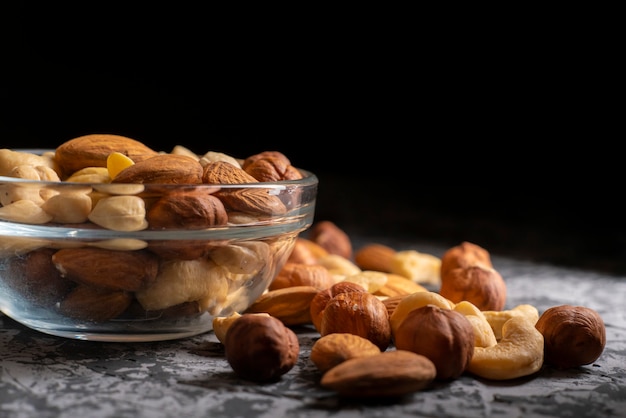 Gemengde verschillende rauwe cocktail noten in een kom op een donkere tafel, gezonde en biologische voeding