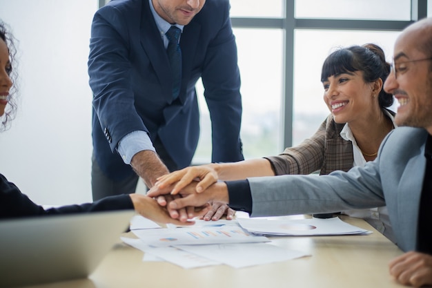 Gemotiveerd opgewonden multiraciaal zakelijk team dat high five geeft om bedrijfsgroei en financieel succes te vieren