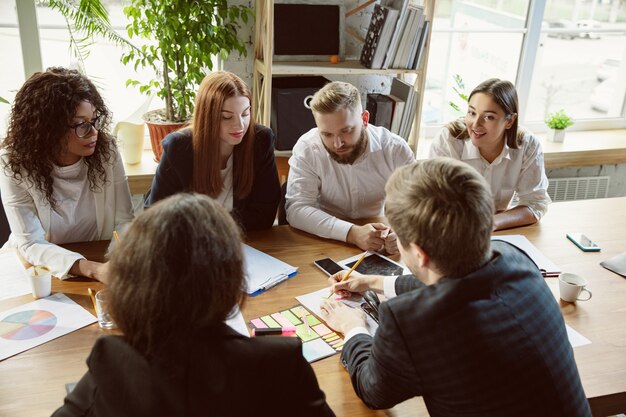 Foto gemotiveerde groep jonge zakelijke professionals die een vergadering hebben