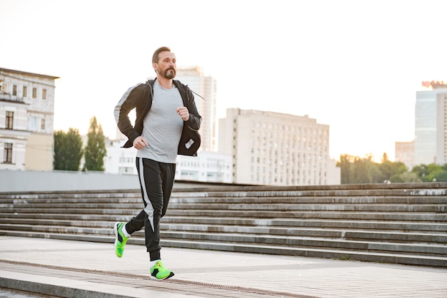 Gemotiveerde sportman die buiten loopt