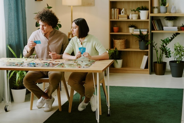 gen y couple playing board gamer at home
