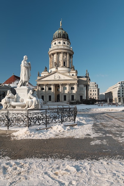 Gendarmenmarktplein in Berlijn met Franse kathedraal of Franzusischer Dom in de Duitse taal Schiller Monument historisch standbeeld van Friedrich Schiller Koude winterdag met blauwe lucht en sneeuw