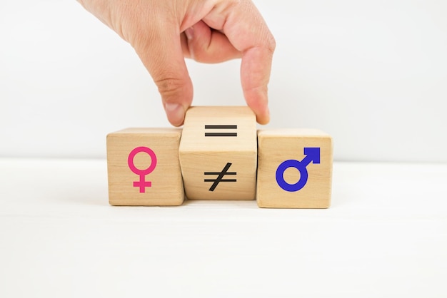 Gender equality symbol the hand rotates the cube and changes\
the inequality sign to an equal sign between the symbols of men and\
women space for copy