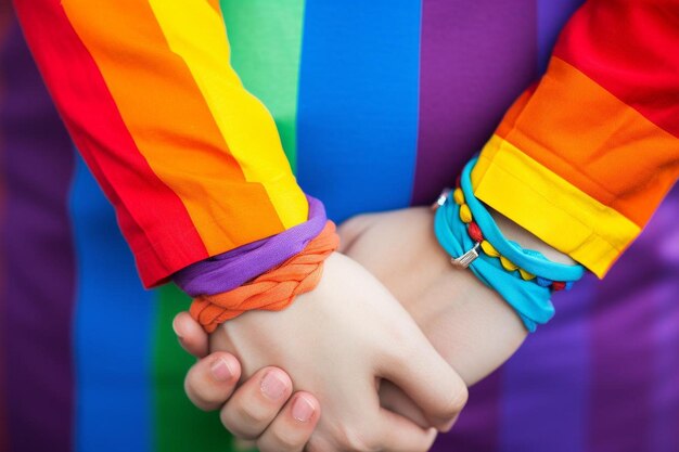 Foto persone di genere fluido mani su sfondo arcobaleno