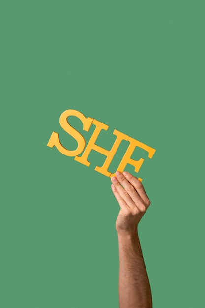 Photo gender fluid person holding a pronoun isolated on green