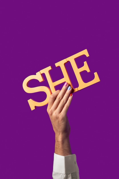 Photo gender fluid person holding a pronoun isolated on purple