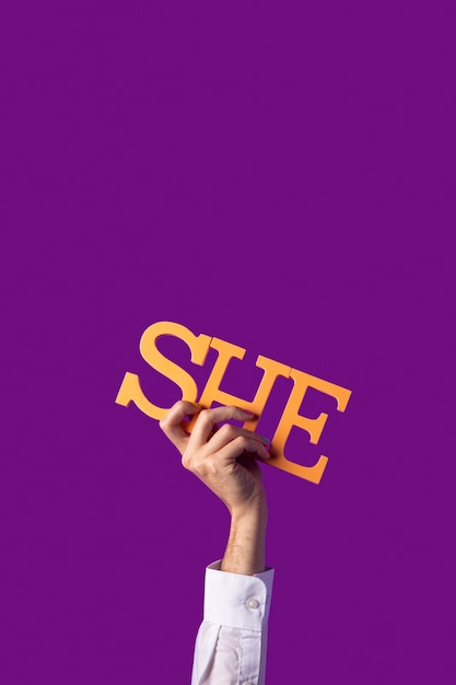 Gender fluid person holding a pronoun isolated on purple