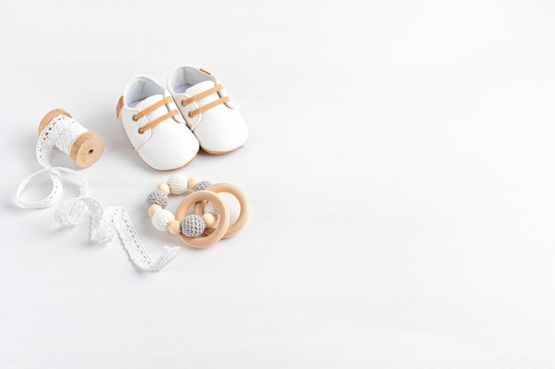 Photo gender neutral baby shoes and accessories. organic newborn fashion, branding, small business idea. baby shower, baptism invitation, greeting card. flat lay, top view