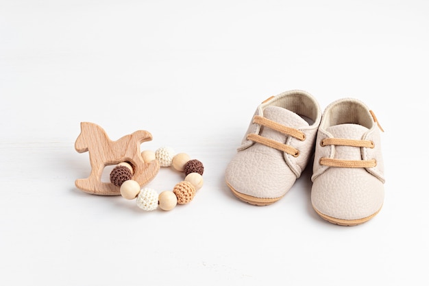 Gender neutral baby shoes and accessories. Organic newborn fashion, branding, small business idea. Baby shower invitation, greeting card. Flat lay, top view