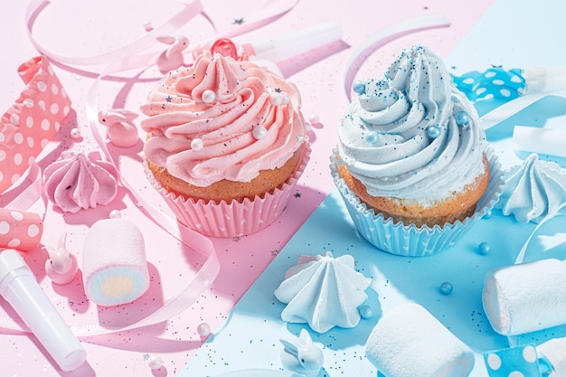 성별 파티 소년 또는 소녀는 파란색과 분홍색 크림 축하 개념이 있는 컵케이크 두 개를 아이의 성별이 알려지면