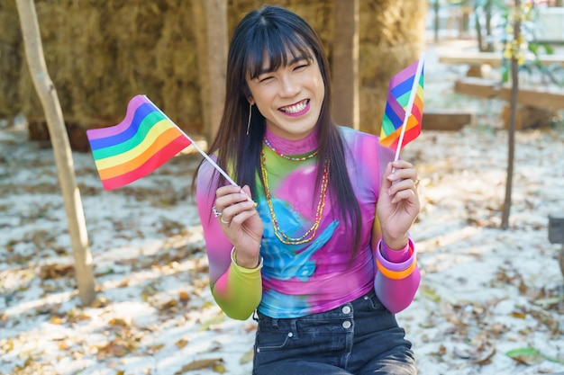 Gender Spectrum smiling happy Thai transgender Asian woman with rainbow flag