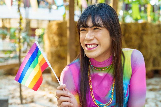 Gender Spectrum smiling happy Thai transgender Asian woman with rainbow flag