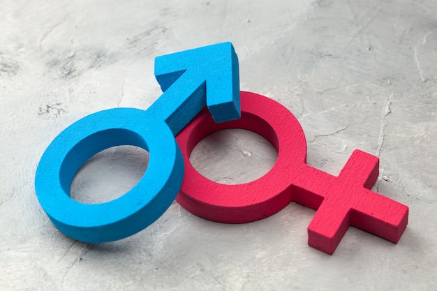 Gender symbols of man and woman on a gray surface.