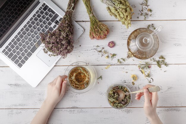 Geneeskrachtige kruiden met recept op houten tafel. Plat liggen