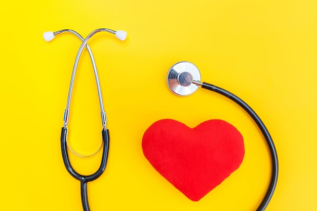 Geneeskunde apparatuur stethoscoop of phonendoscope en rood hart geïsoleerd op trendy gele achtergrond