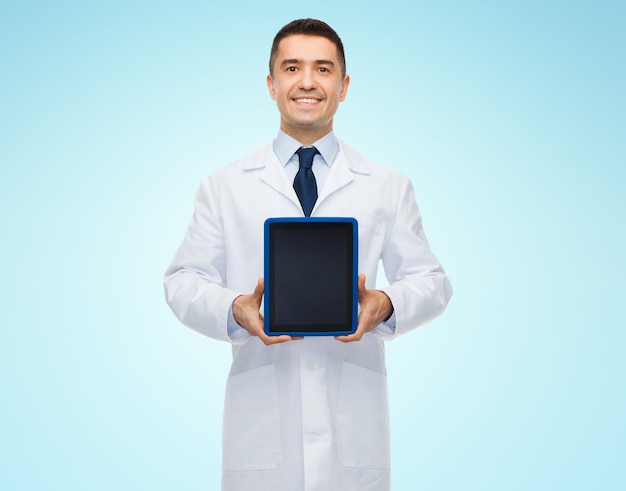 geneeskunde, beroep, reclame en gezondheidszorgconcept - glimlachende mannelijke arts die het lege scherm van de tabletpc toont